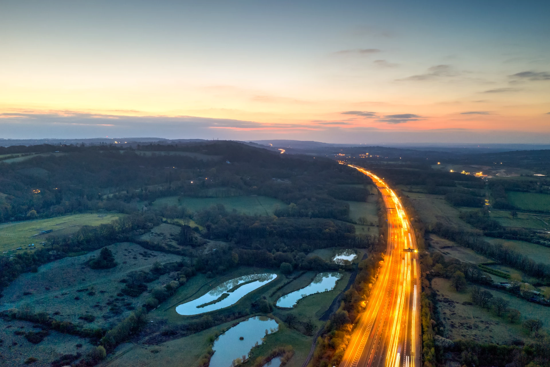 Photograph with long exposure setting to show car lights on the motorway through the countryside