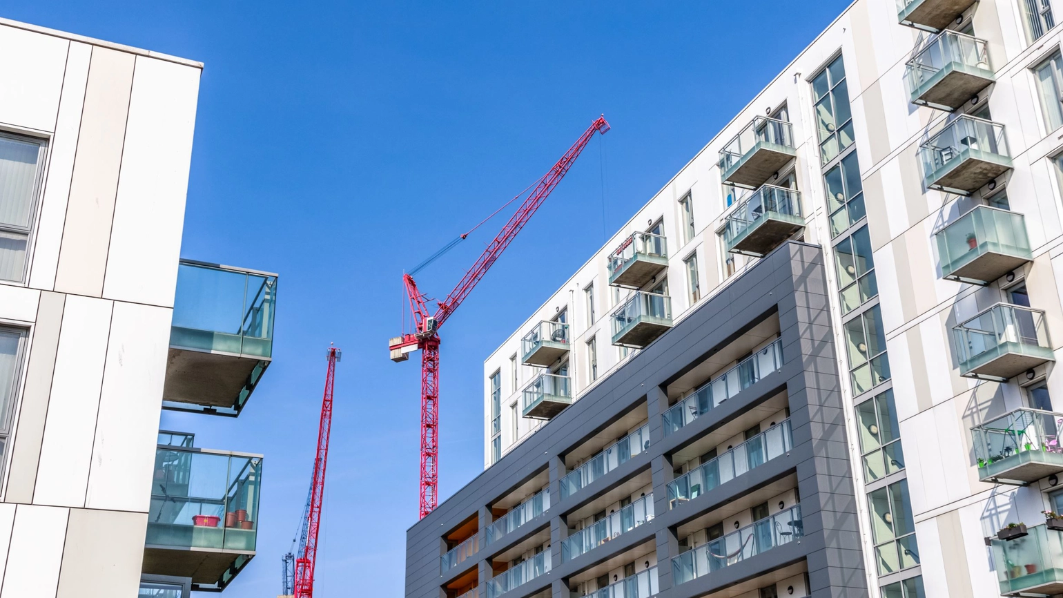 A red crane above a residential building A red crane above a residential building