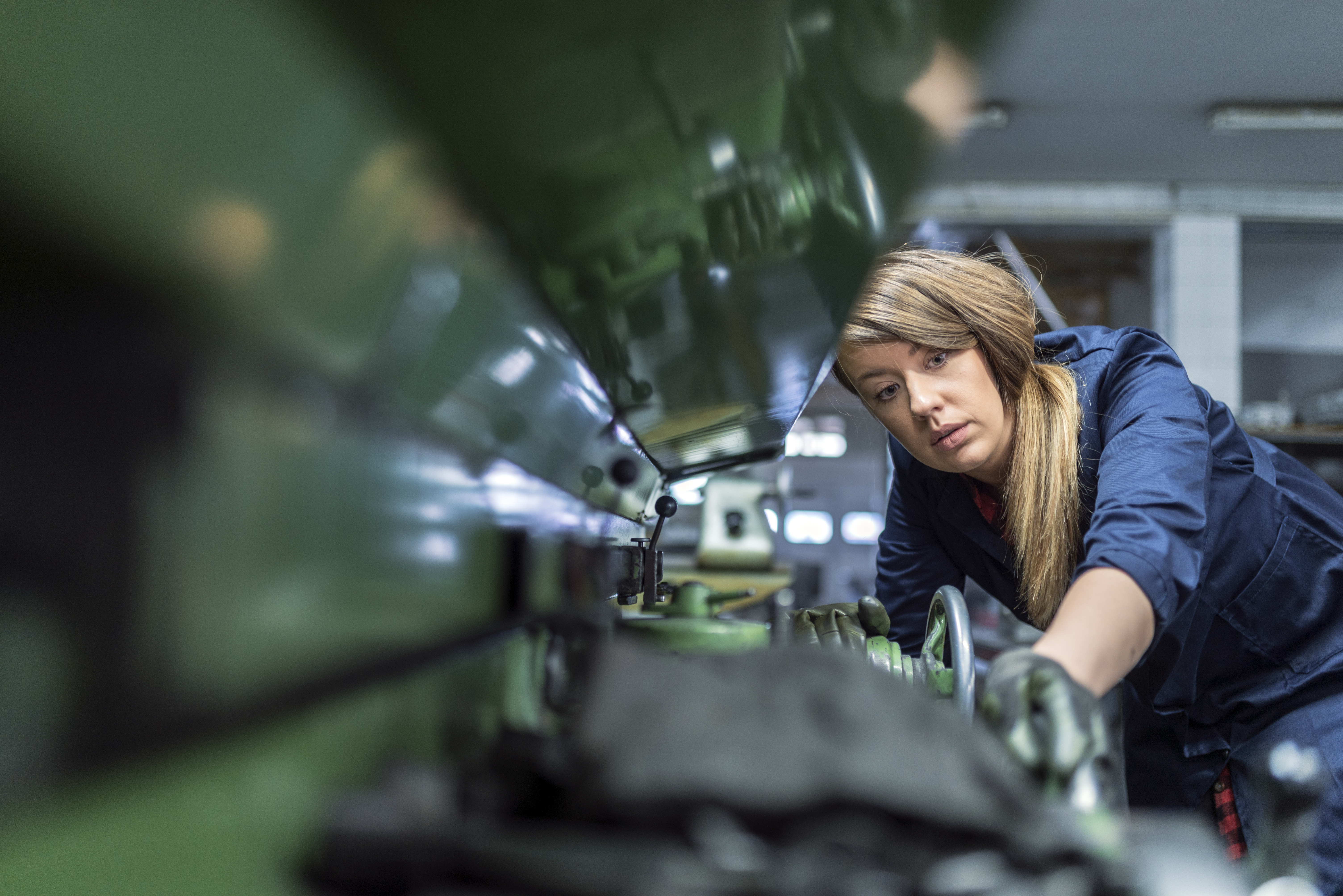 Person operating an industrial machine in a workshop.