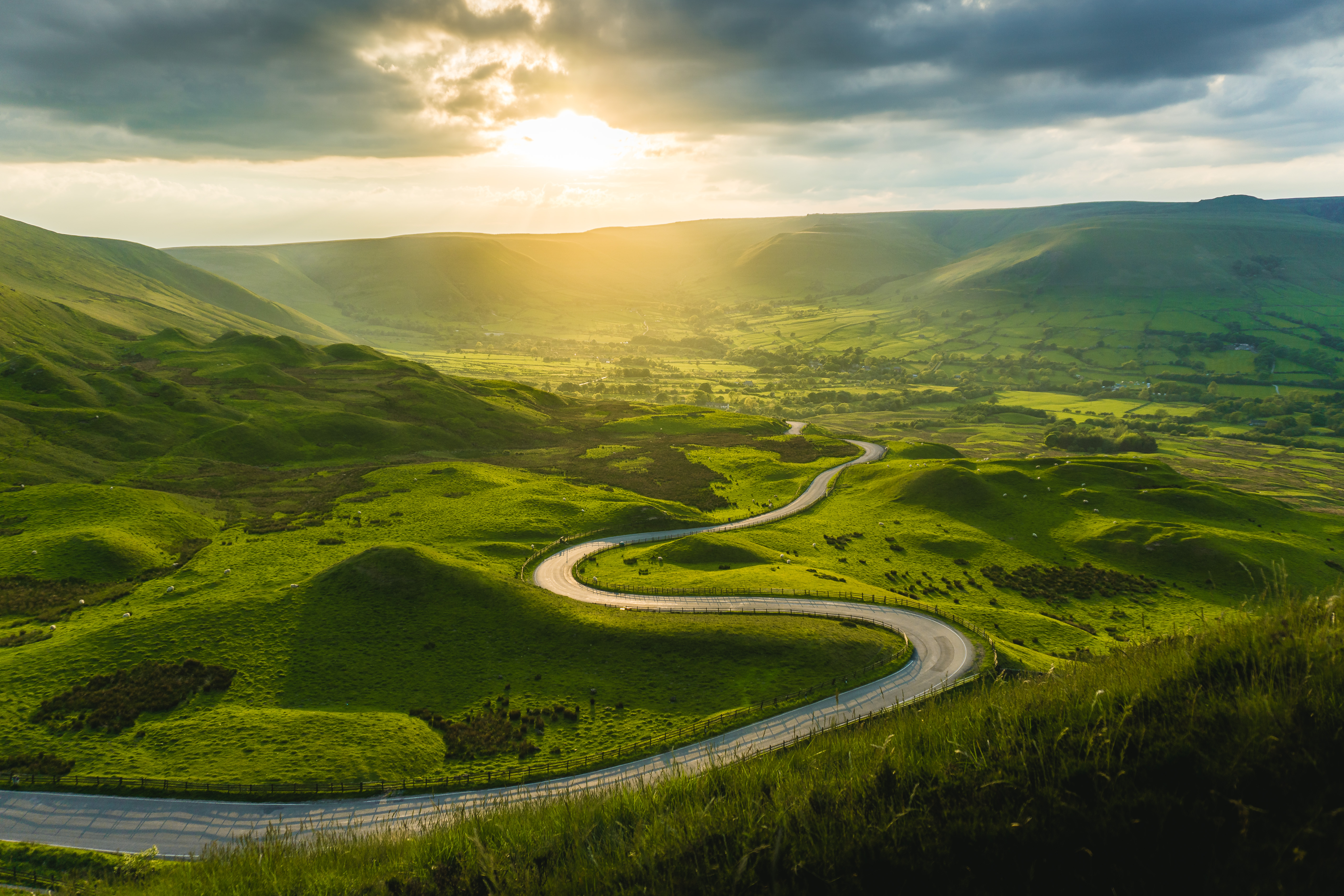 Road winding through green hills, Derbyshire, UK.